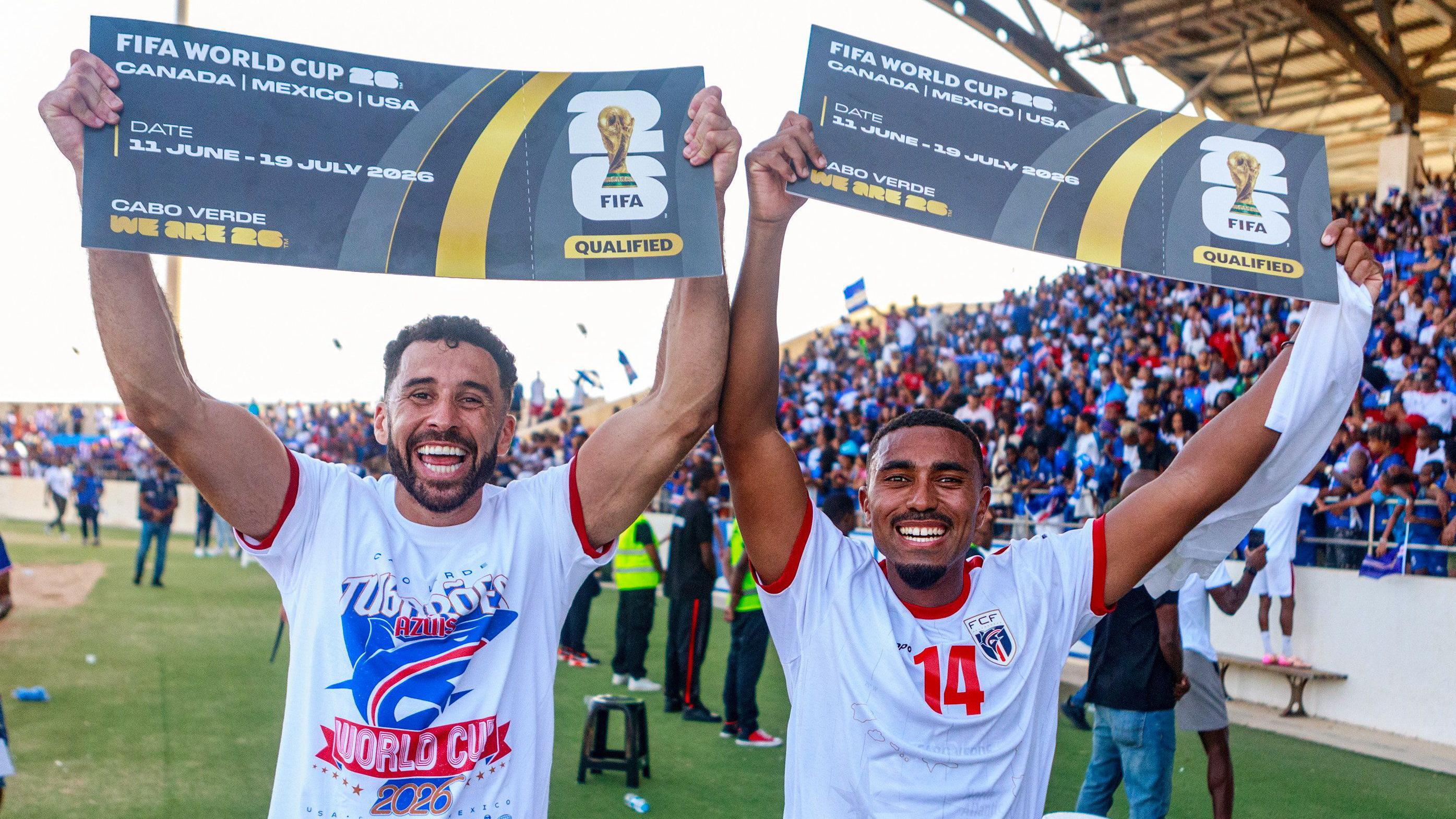 Os jogadores de futebol Roberto Lopes e Deroy Duarte comemoram a classificação de Cabo Verde para disputar sua primeira Copa do Mundo, no Estádio Nacional da Praia, em 13 de outubro de 2025