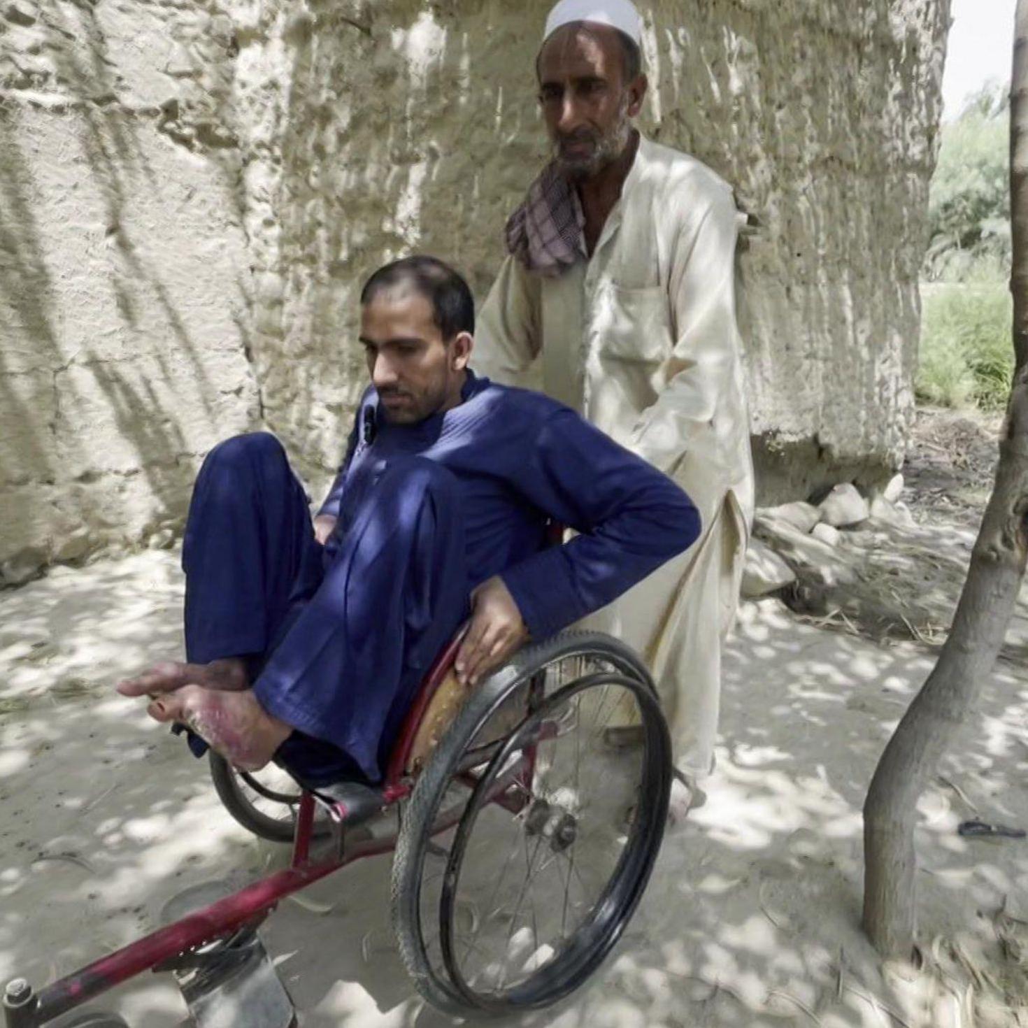رجل يدفع آخر على كرسي متحرك