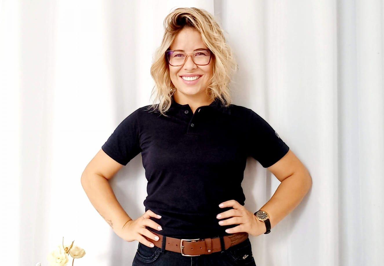 Rafaela Barbosa, m&atilde;e de um estudante que estuda em col&eacute;gio c&iacute;vico-militar, em um retrato; ela usa camisa preta, cinto e est&aacute; com os cabelos soltos; o fundo &eacute; branco