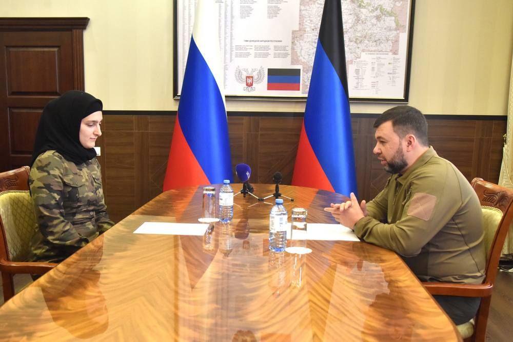 Айшат Кадирова сидить за столом у кабінеті Дениса Пушиліна. Обидва дивляться в стіл