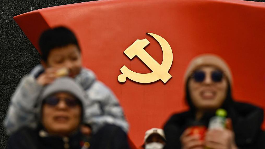 中共黨徽標誌，前方是人群