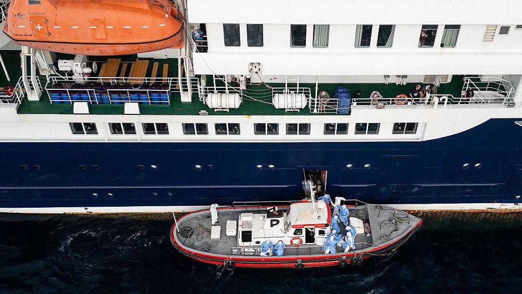 Esta vista aérea muestra al personal sanitario ayudando a pacientes a subir a un bote desde el crucero MV Hondius, mientras se encontraba anclado frente al puerto de Praia, la capital de Cabo Verde, el 6 de mayo de 2026.