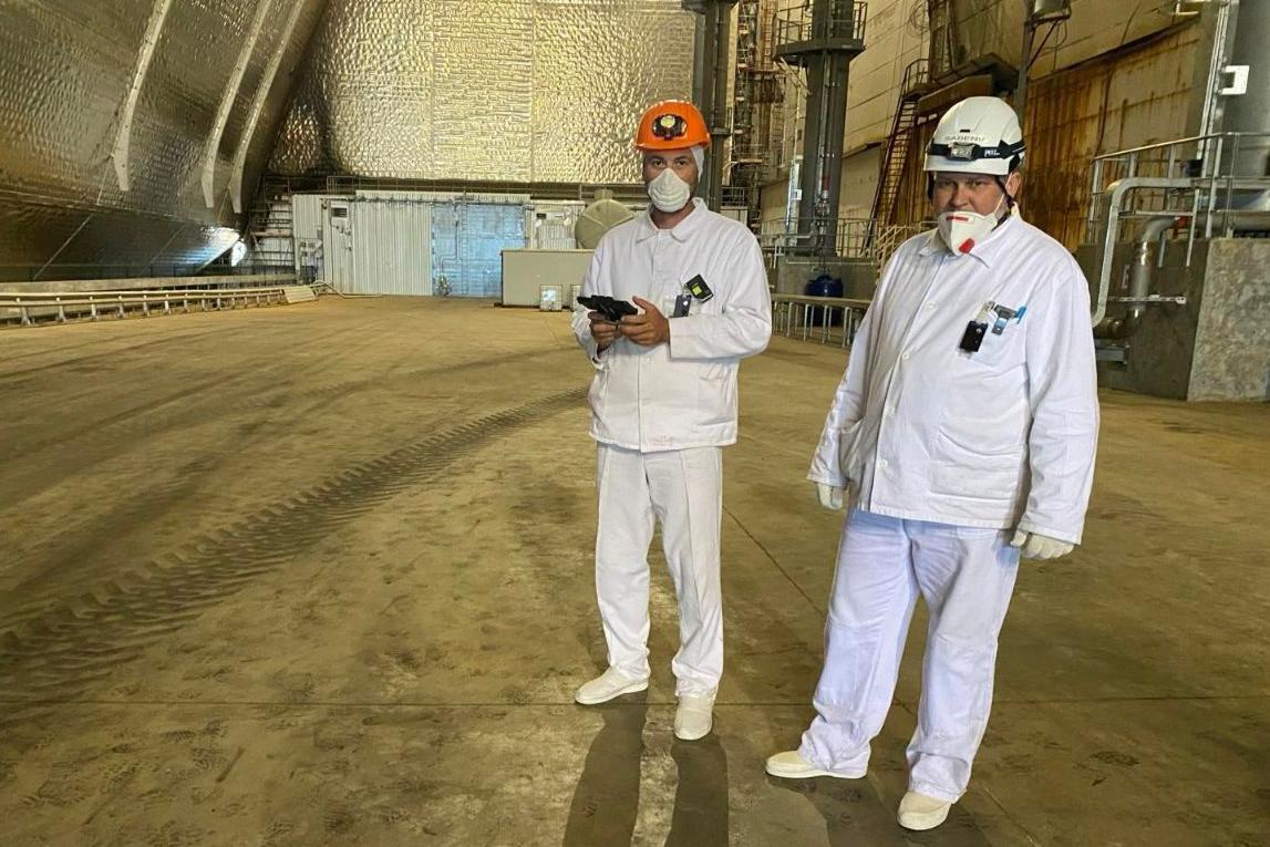 Doroshenko de p&eacute;, ao lado de um companheiro de trabalho, dentro do domo que protege o reator 4 da usina nuclear de Chernobyl