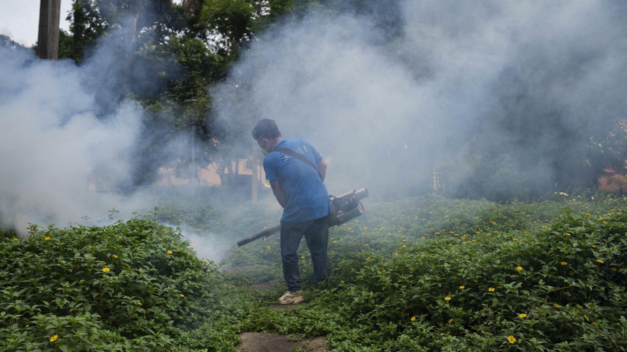 廣東佛山一名身穿深藍色汗衫，戴上口罩的防疫工作人員在一家醫院內噴灑消毒噴霧（23/7/2025）