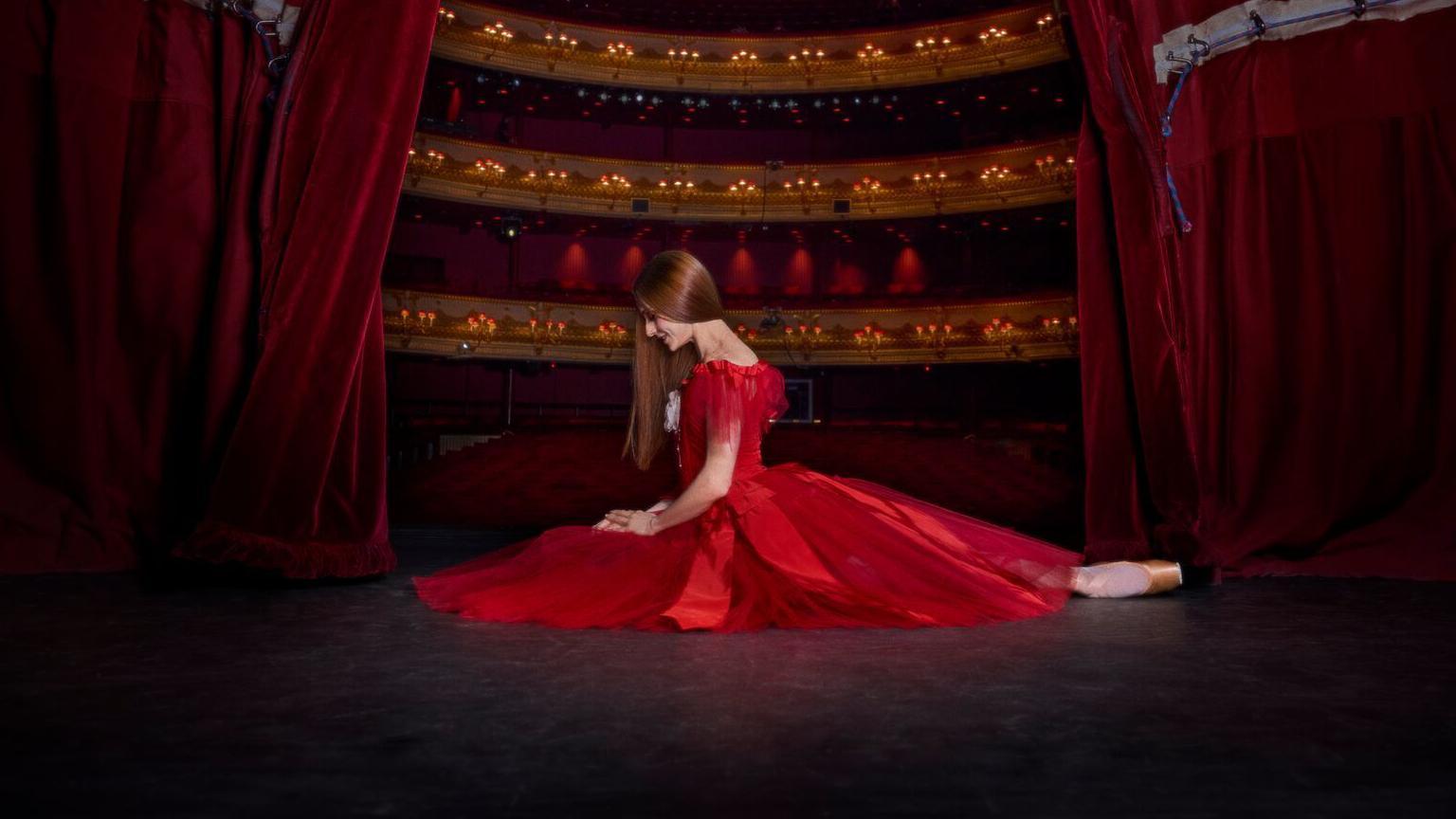 Marianela Núñez, abierta de piernas con un vestido rojo sobre el escenario del Royal Opera House de Londres. 
