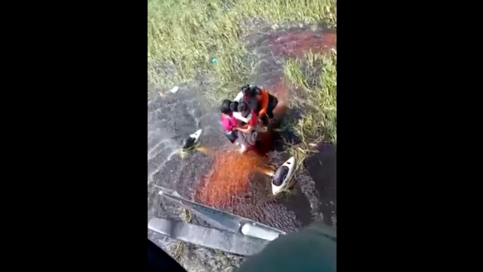 imagem feita a partir de helicoptero mostra passageiros abraçados em meio a um pântano