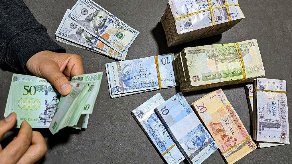 الدولار الأمريكي مقابل أوراق نقدية متنوعة.
