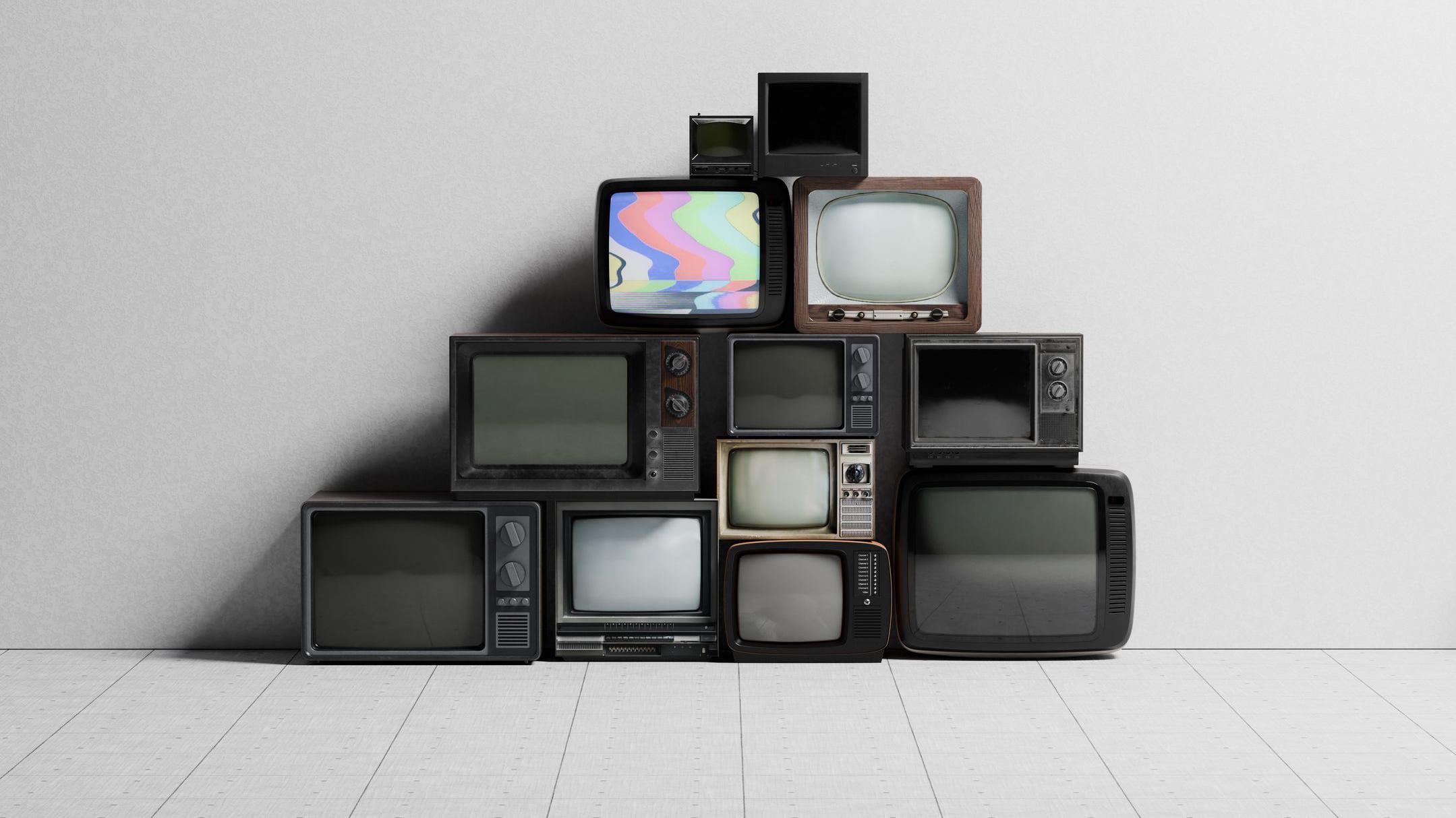 TVs de diversos tamanhos e aparências empilhadas