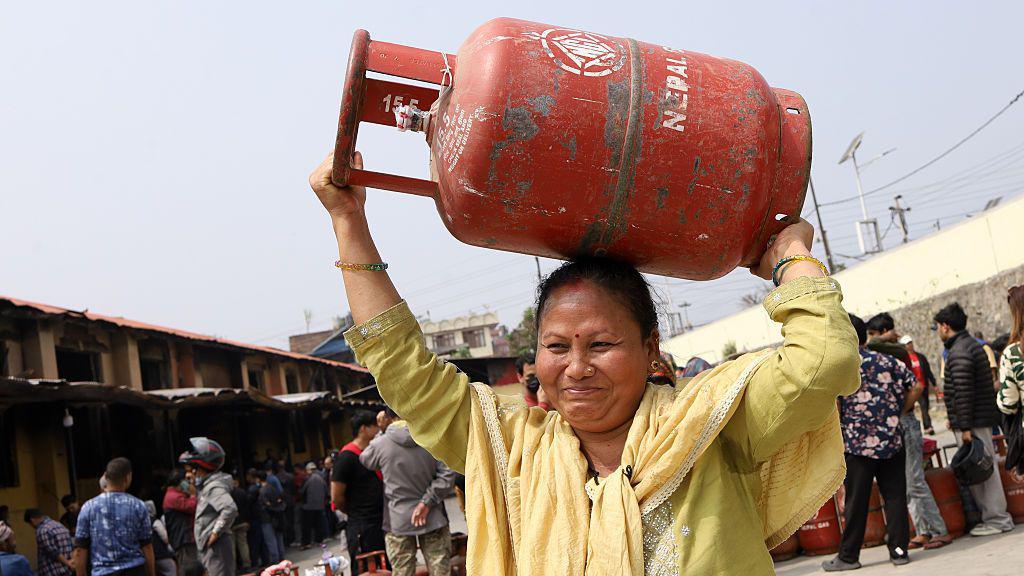 隨著伊朗戰爭進入第二週，供應中斷，國家壟斷企業尼泊爾石油公司（NOC）開始實施液化石油氣（LPG）即廚用瓦斯的配給制度，以應對需求激增。根據尼泊爾石油公司的命令，裝瓶廠開始向顧客銷售半滿的瓦斯罐，迫使人們排長隊等候數小時。根據新規定，無論是家庭用戶還是旅館餐廳用戶，都將獲得 7.1 公斤的瓦斯罐，容量是通常的一半。這家國家壟斷企業聲稱，儘管進口未受影響，此舉旨在節約能源。一個 7.1 公斤的廚用瓦斯罐售價為 955 尼泊爾盧比。尼泊爾石油公司的這項決定距上一次實施已間隔 5 年。尼泊爾石油公司在 2015 年和 2020 年的先前危機期間也曾採取類似措施，當時該國遭遇了嚴重的廚用瓦斯短缺。這家燃料壟斷企業表示，來自印度的供應保持正常，但加德滿都谷地的搶購現象愈演愈烈。中東地區是全球市場的主要燃料供應地區，隨著該地區地緣政治緊張局勢升級，當地雜貨店無法在整個谷地供應燃料後，廚用瓦斯倉庫前的隊伍越來越長。