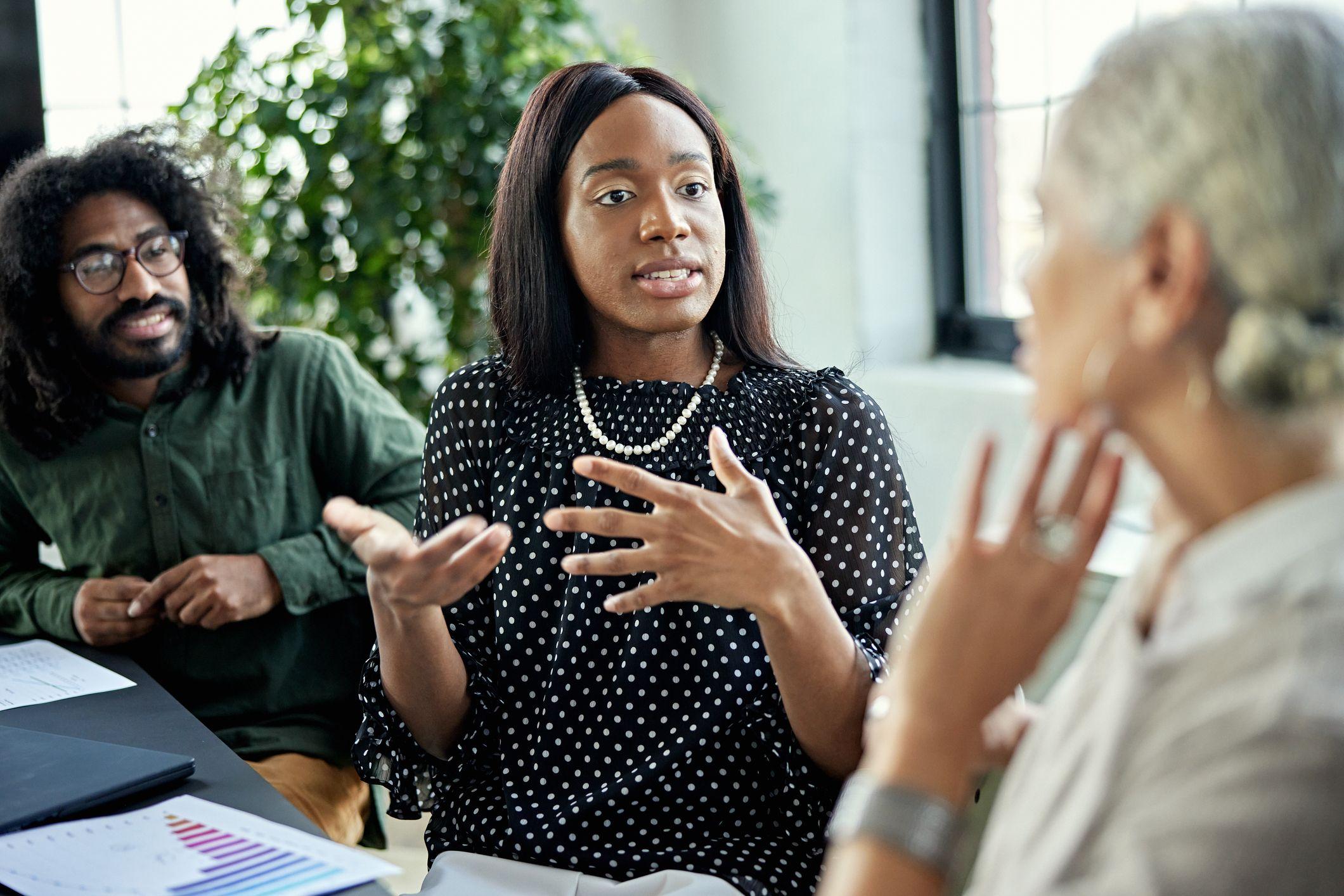 سيدة تناقش شاباً عن يمينها وسيدة أخرى عن يسارها