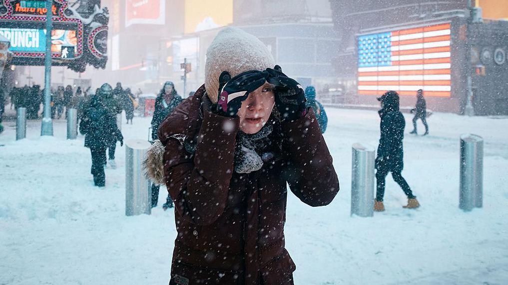 Una mujer se protege la cara mientras camina durante la tormenta de nieve el 25 de enero de 2026 en la ciudad de Nueva York.