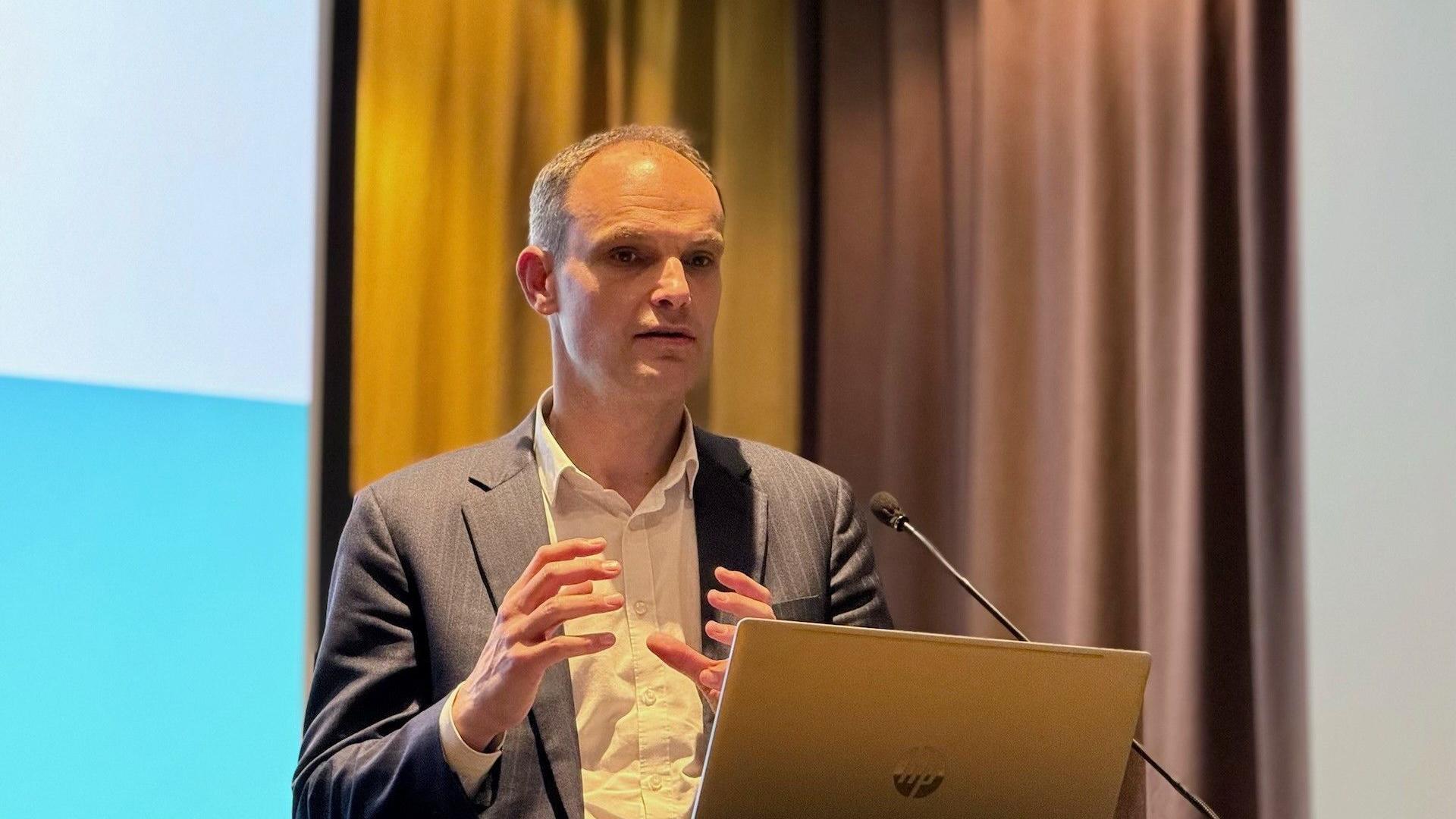 Političar Anže Logar u odelu za govornicom