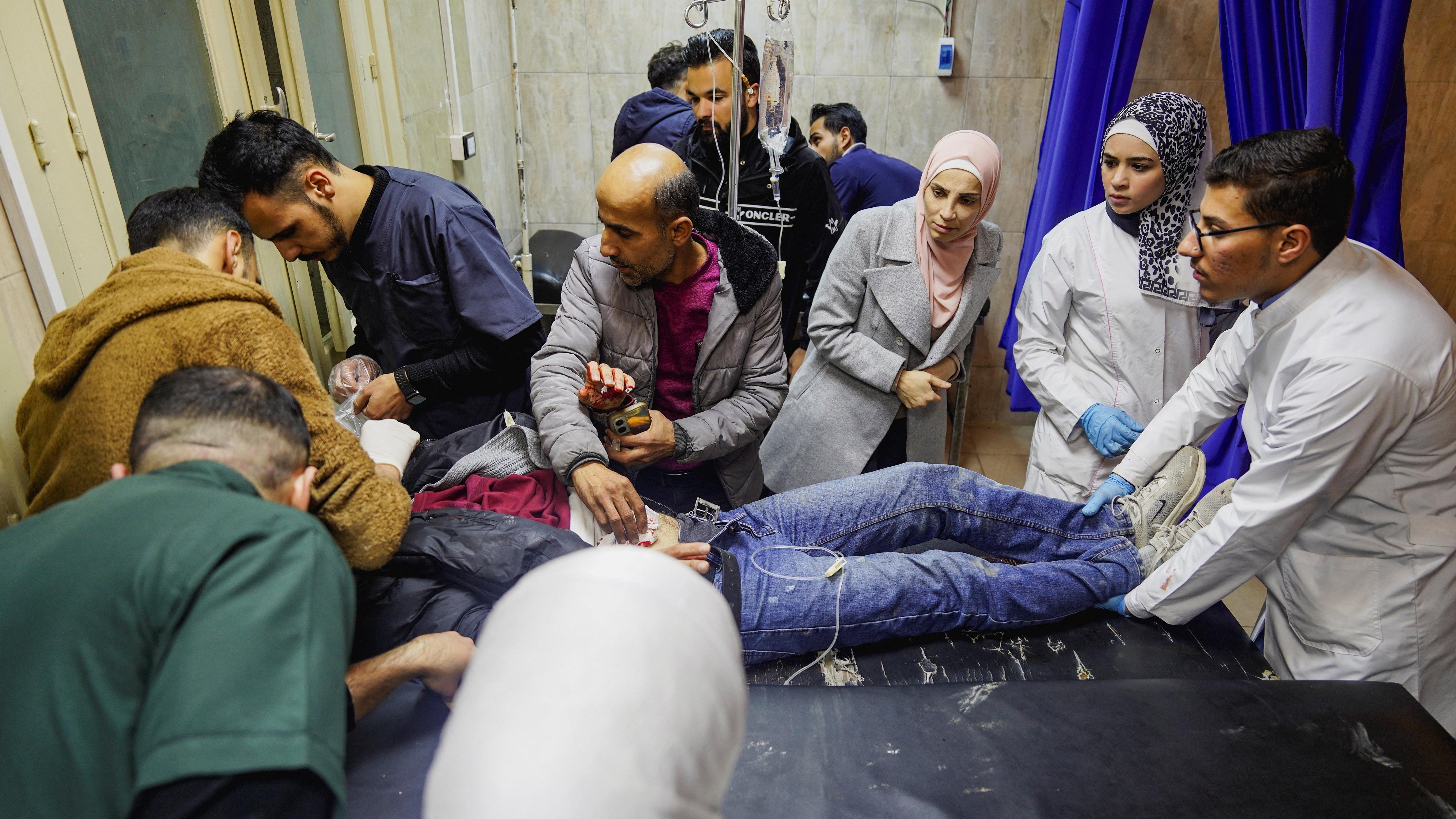 مسعفون مع جريح على نقالة داخل مستشفى، خلال اشتباكات بين القوات الحكومية وقوات سوريا الديمقراطية بقيادة الأكراد في مدينة حلب شمال سوريا.