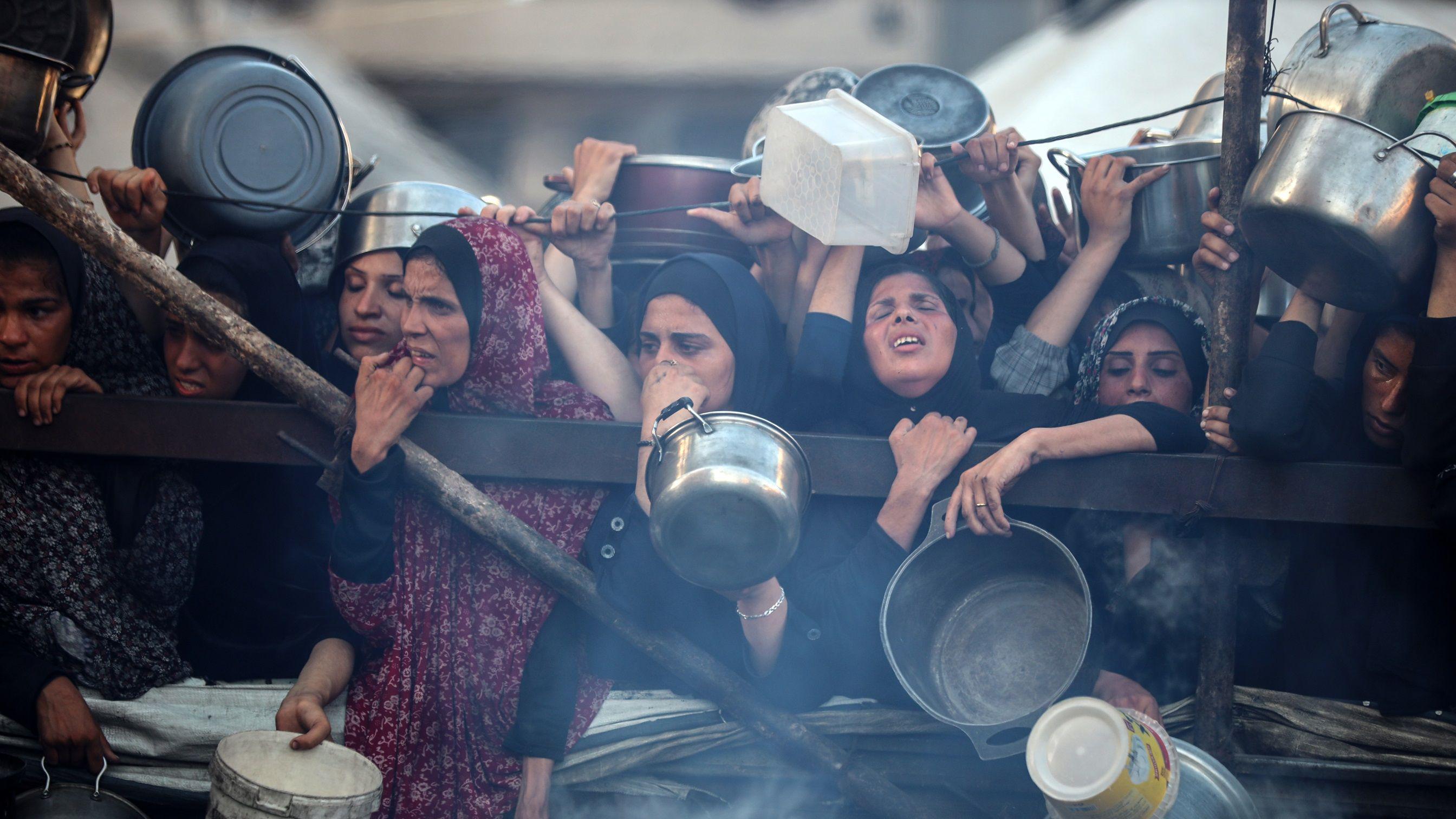 فلسطينيون يتجمعون عند نقطة توزيع طعام في مدينة غزة، 20 يوليو/تموز 2025. أفاد برنامج الغذاء العالمي أن ما يقرب من ثلث سكان غزة لا يأكلون لأيام متواصلة، وأن "الآلاف" على "حافة جوع كارثي".