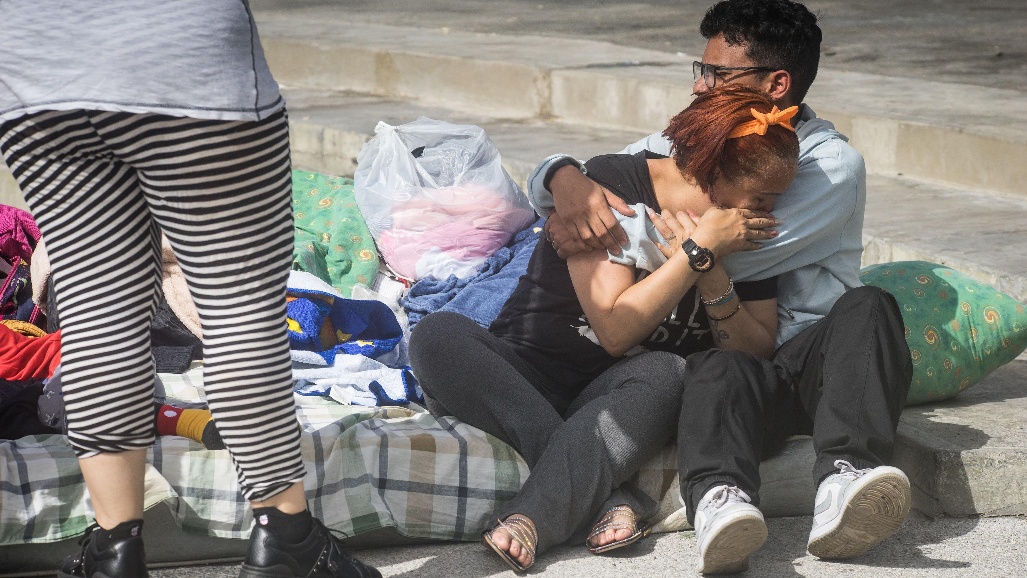 Una mujer llora y un hombre la abraza, mientras aguardan en el parque Alí Primera, en el oeste de Caracas. 