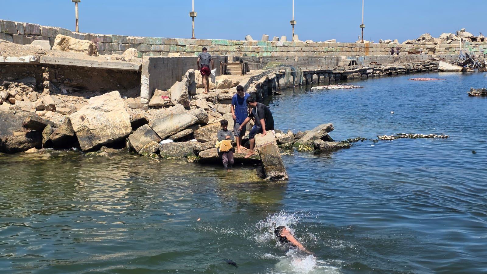 غزيون يبحثون عن الصخور في ميناء غزة وبحرها