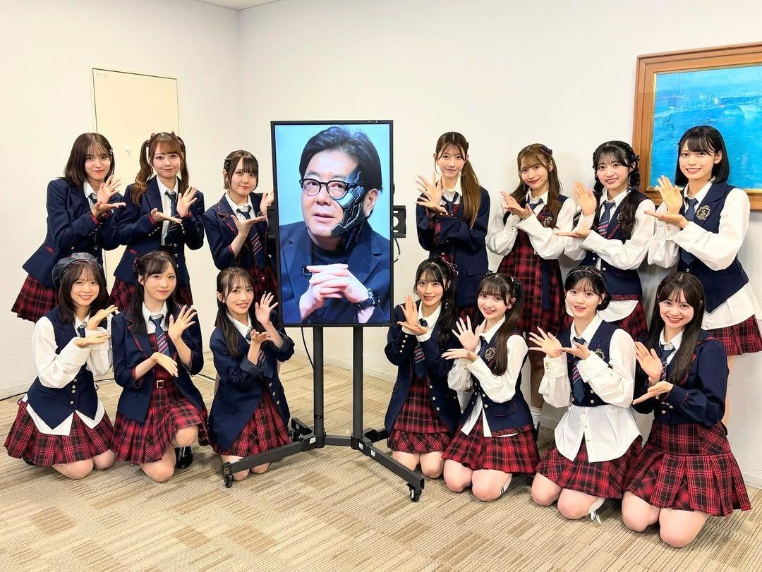 AKB48成員與螢幕上的「AI版秋元康」合照。