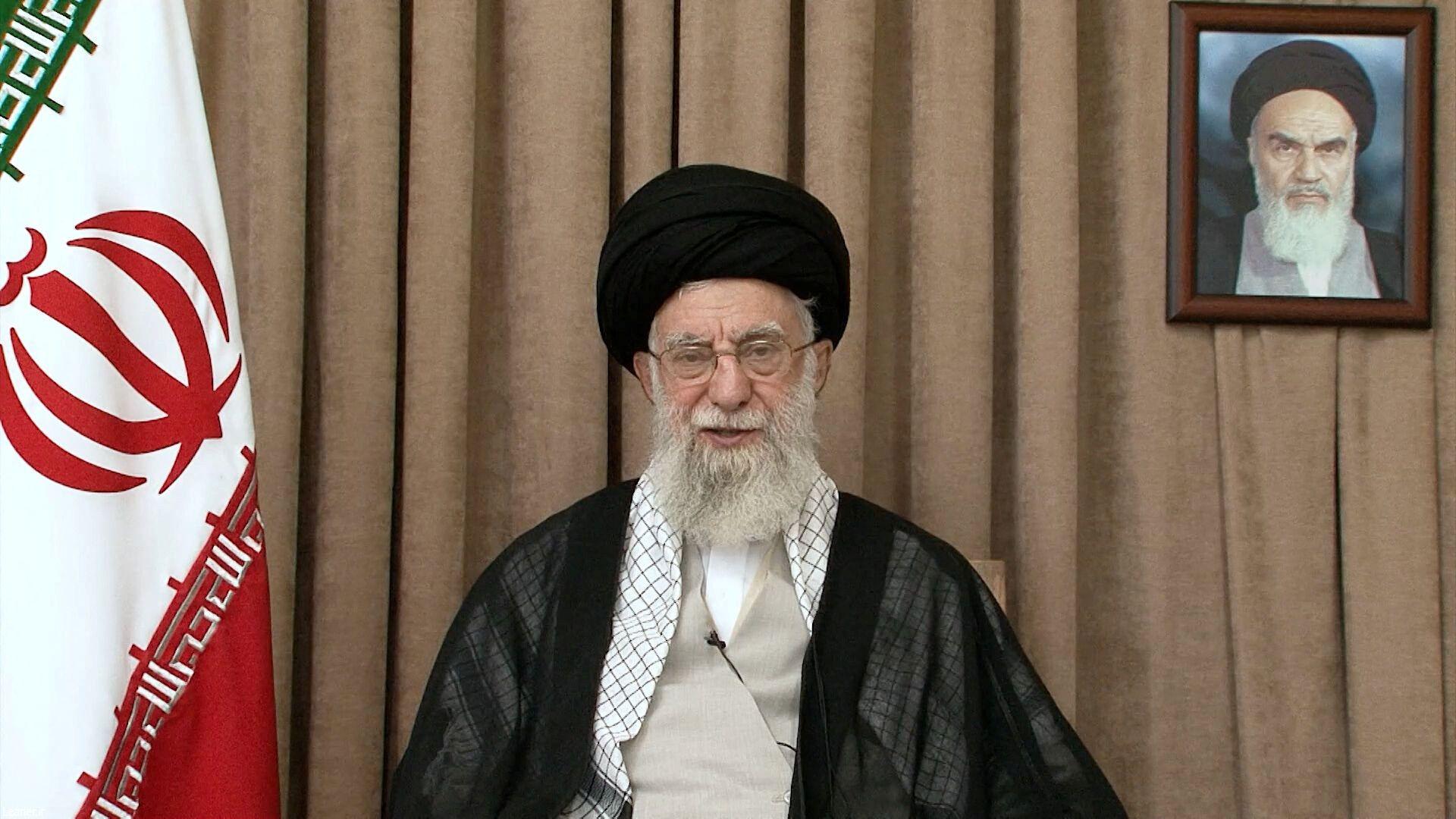 Aiatolá Ali Khamenei, líder supremo do Irã, entre a bandeira do país e a foto do aiatolá Khomeini