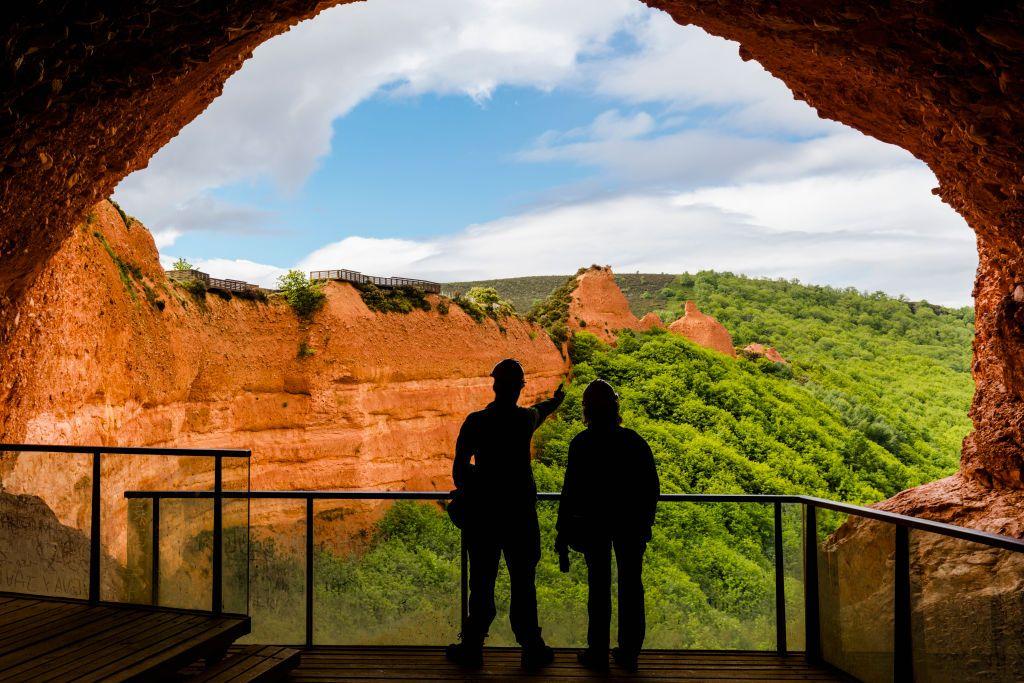 Una pareja ve Las Médulas desde un mirador dentro de una de las cavernas hechas por los romanos.