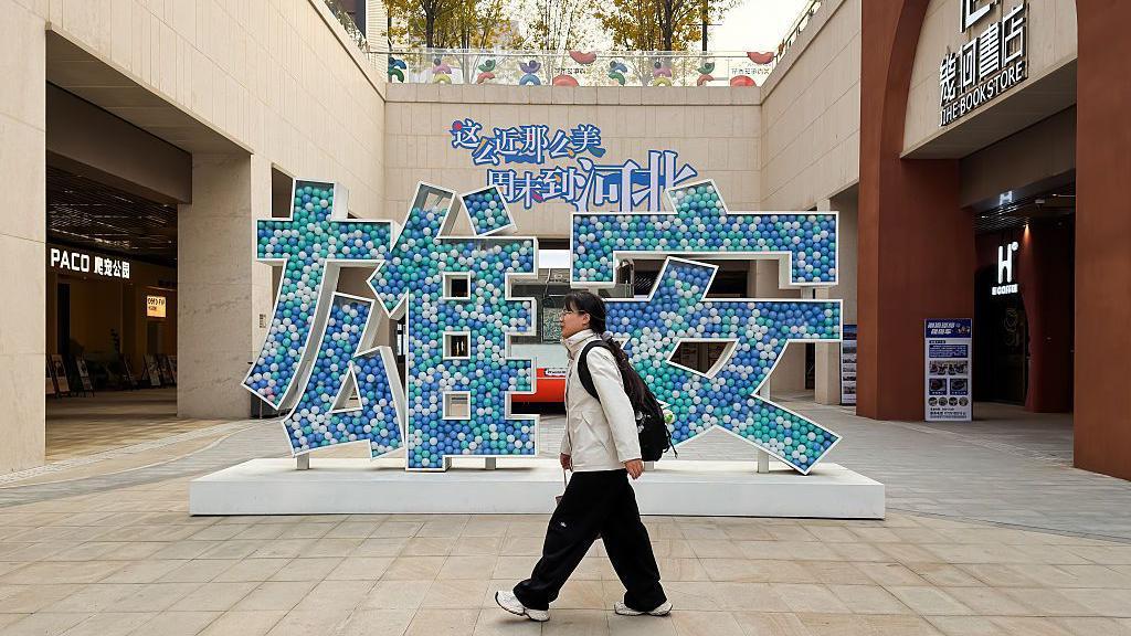 一個女生走過雄安兩個大字