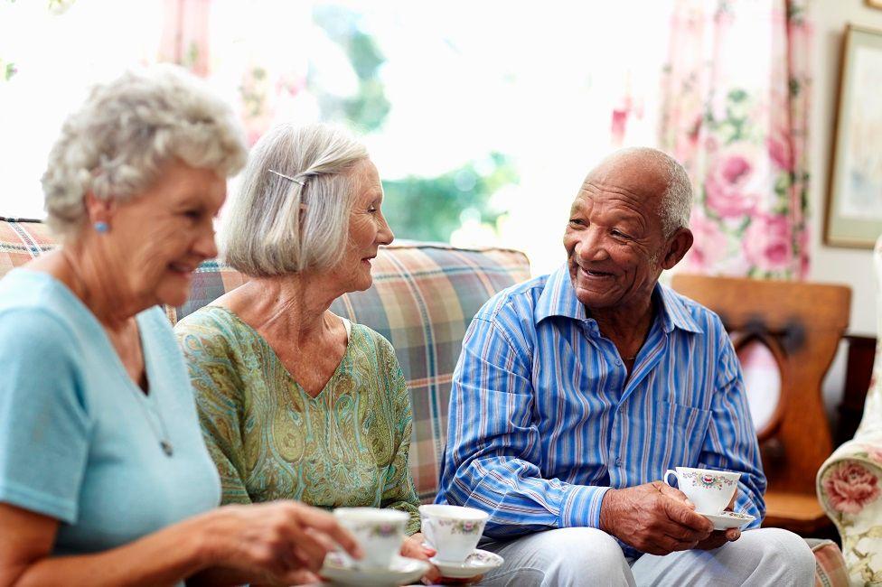 Tres personas mayores tomando café