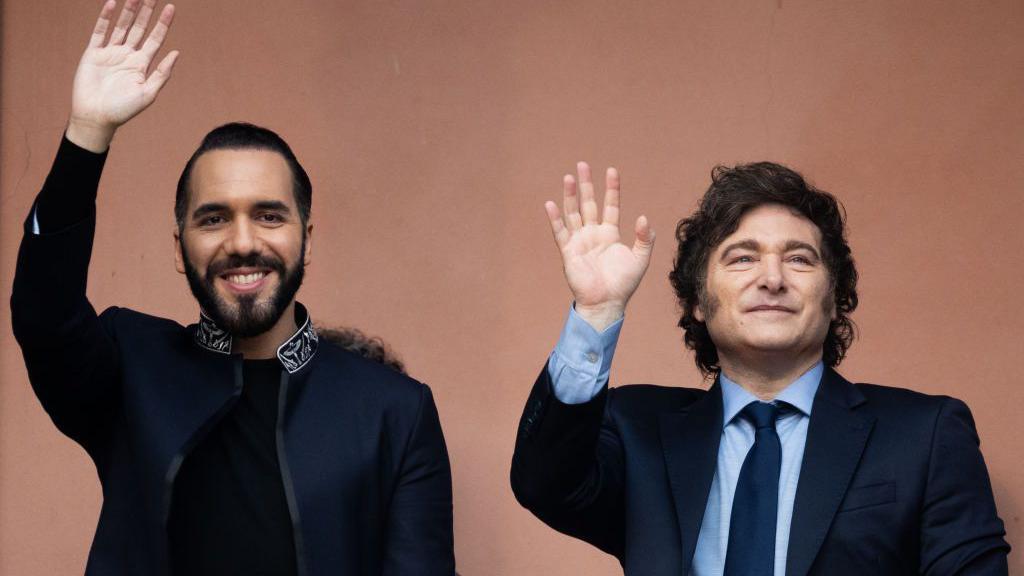 El presidente de El Salvador, Nayib Bukele, con el presidente de Argentina, Javier Milei, saludan desde un balcón.