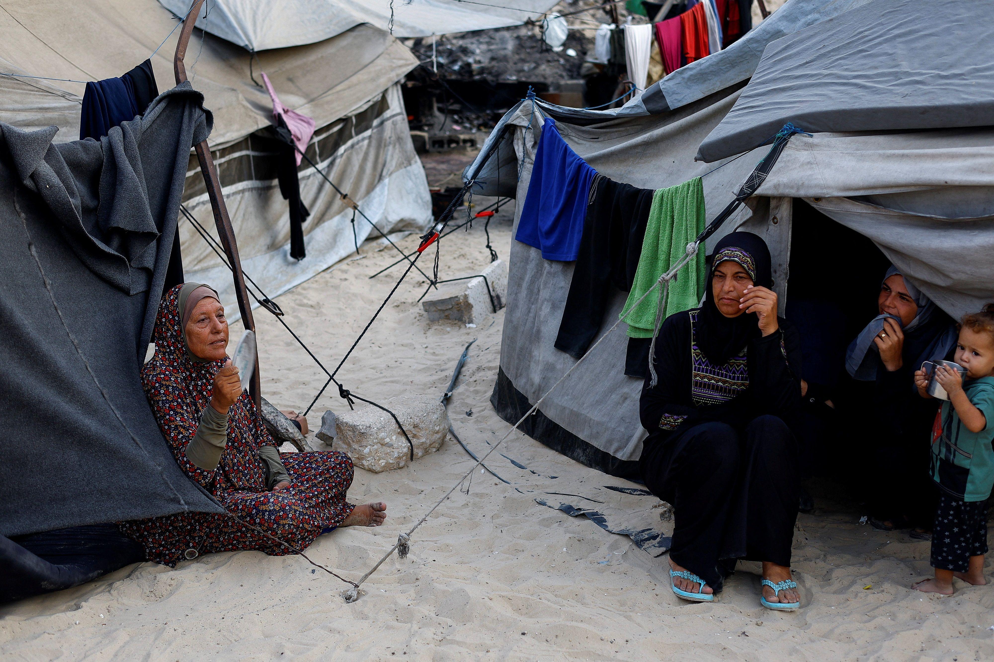 فلسطينيون نزحوا بسبب الهجوم الإسرائيلي، يحتمون في مخيم على الشاطئ وسط حرارة الصيف، في مدينة غزة، 12 أغسطس/آب 2025.