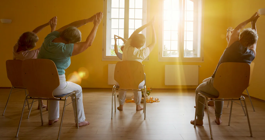 سيدات كبار في السن يقمن بتمارين رياضية أثناء جلوسهن على الكراسي