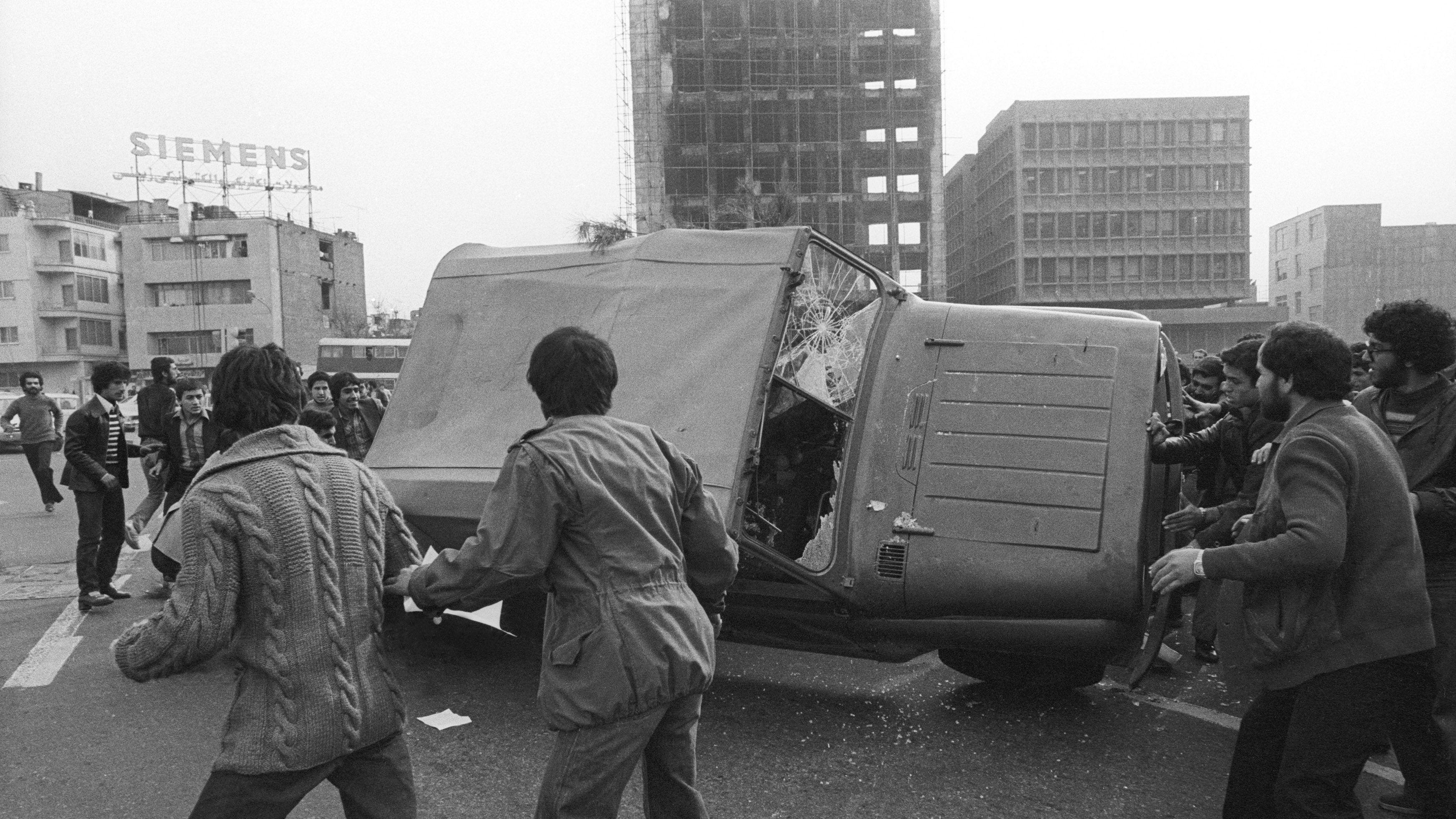 قام الناس بتحطيم وإسقاط سيارة جيب عسكرية في ميدان شريفار رقم 25، طهران، خلال الثورة الإسلامية، 15 فبراير/شباط 1979. 