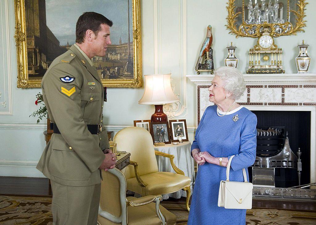 La reina Isabel II (d.) saluda al cabo australiano Ben Roberts-Smith (i.), quien fue recientemente condecorado con la Cruz Victoria, durante una audiencia en el Palacio de Buckingham, en Londres, el 15 de noviembre de 2011.