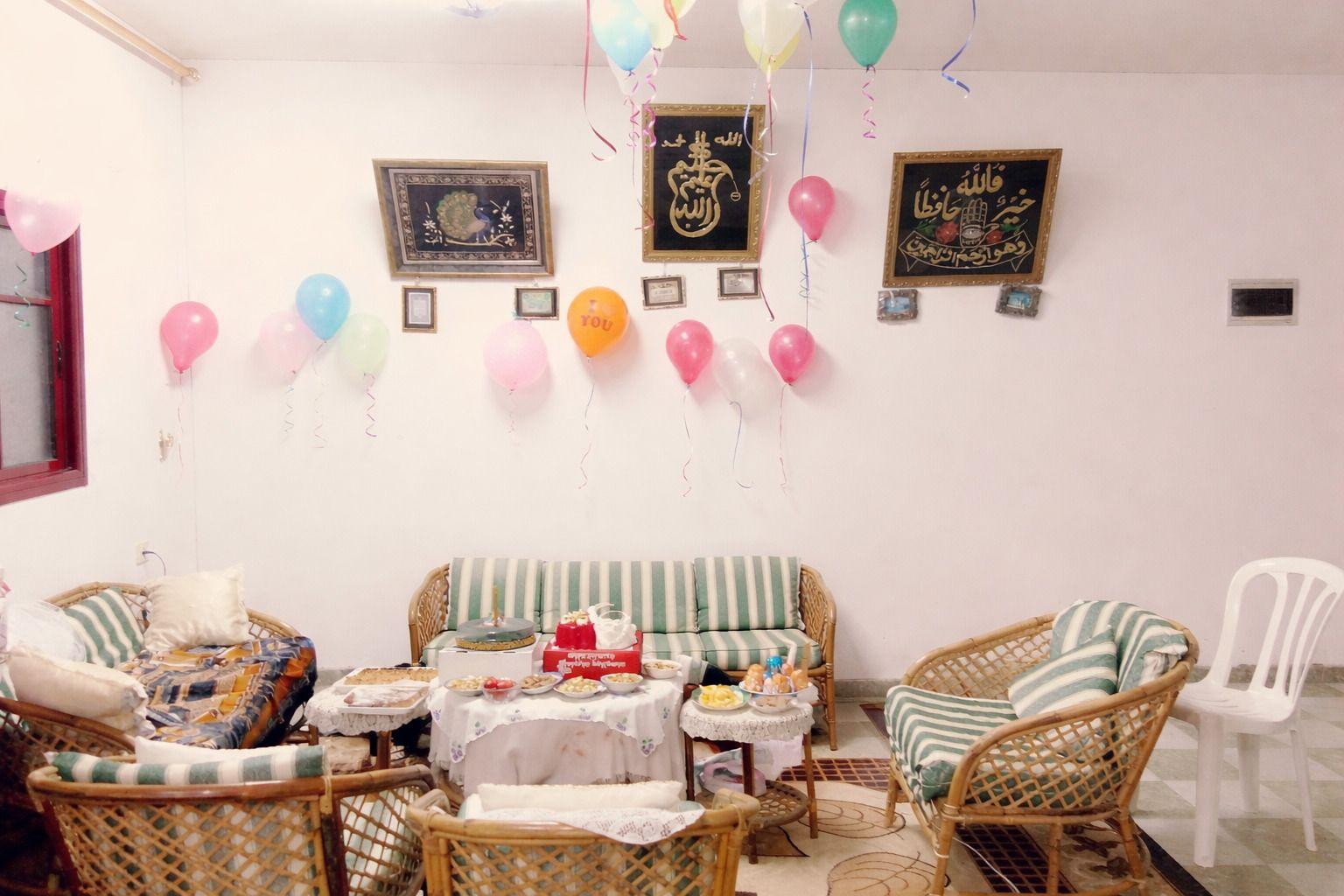 Sala com bal&otilde;es de festa, sof&aacute;s e comida em mesas