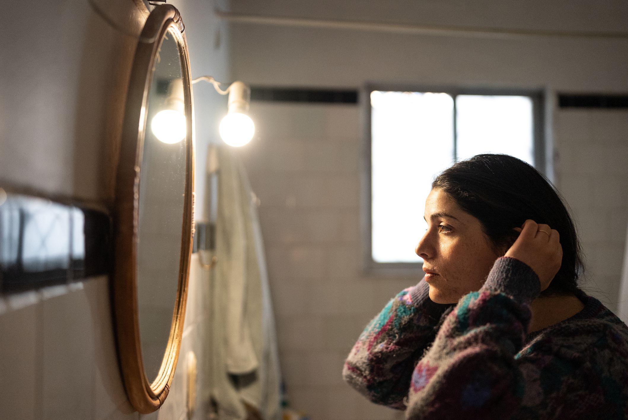 Mulher se arrumando em frente ao espelho