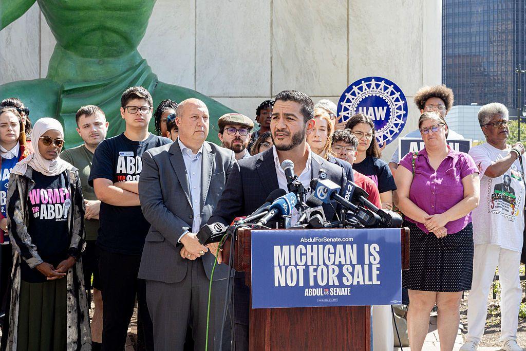 عبد الرحمن السيد، مرتديا سترة زرقاء وقميصا أبيض، ويلقي كلمة أمام وسائل الإعلام بعد إعلان فوزه بترشيح الحزب الديمقراطي لخوض انتخابات مجلس الشيوخ عن ولاية ميشيغان، وخلفه عدد من مؤيديه، يرتدي بعضهم قمصانا تحمل اسم السيد.