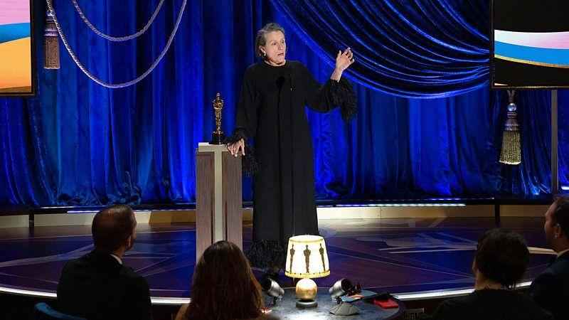 Frances McDormand, de vestido preto, recebendo o Oscar de Melhor Atriz, em 2021