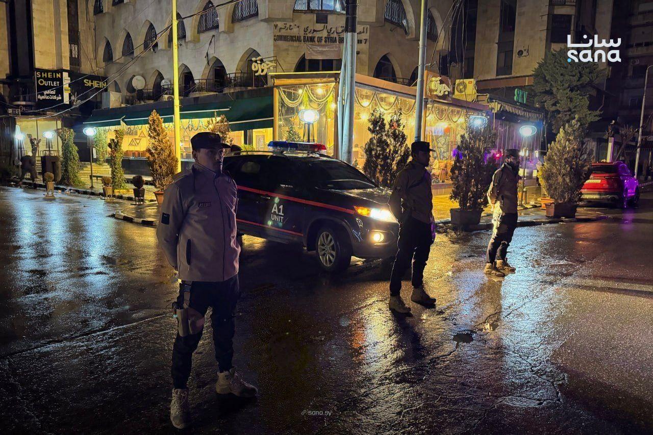 رجال أمن يقفون أمام سيارة للشرطة في إجراءات أمنية احترازية في حلب عقب التفجير