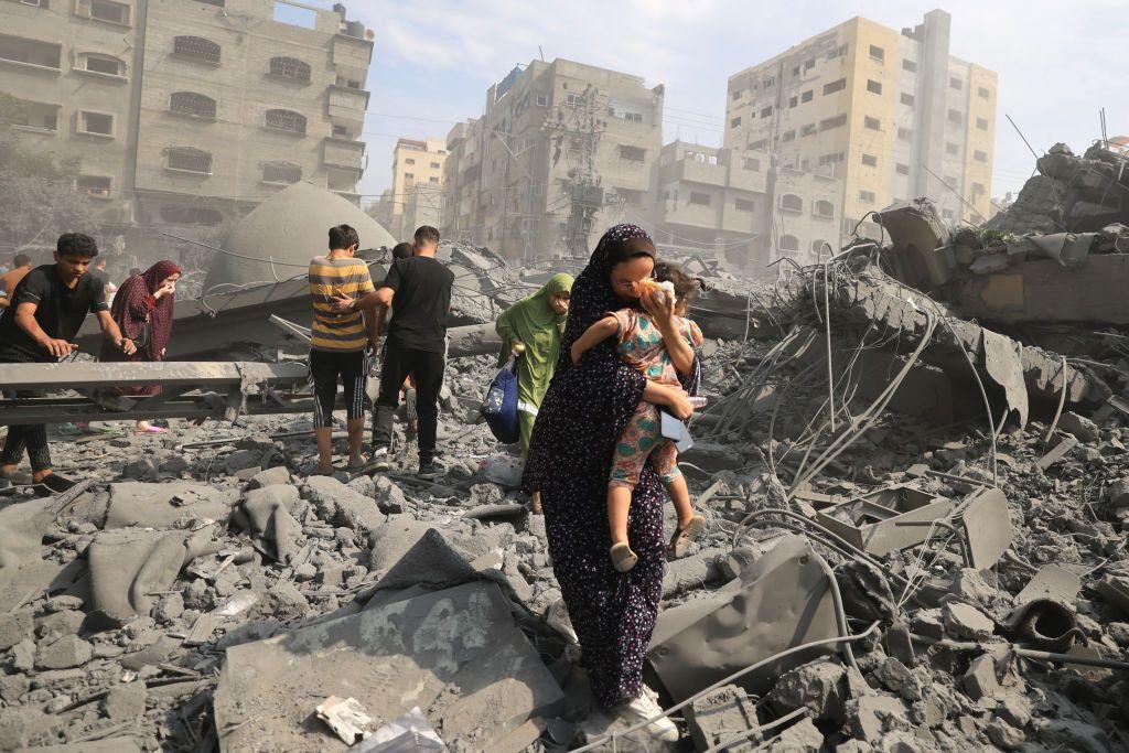 Mujer camina por los escombros en los territorios palestinos.