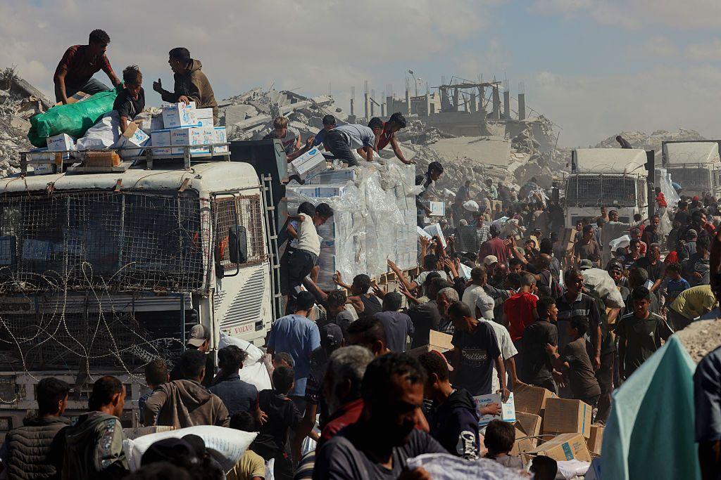 Una muchedumbre se arremolina junto a camiones de reparto de ayuda en Jan Yunis, Gaza.