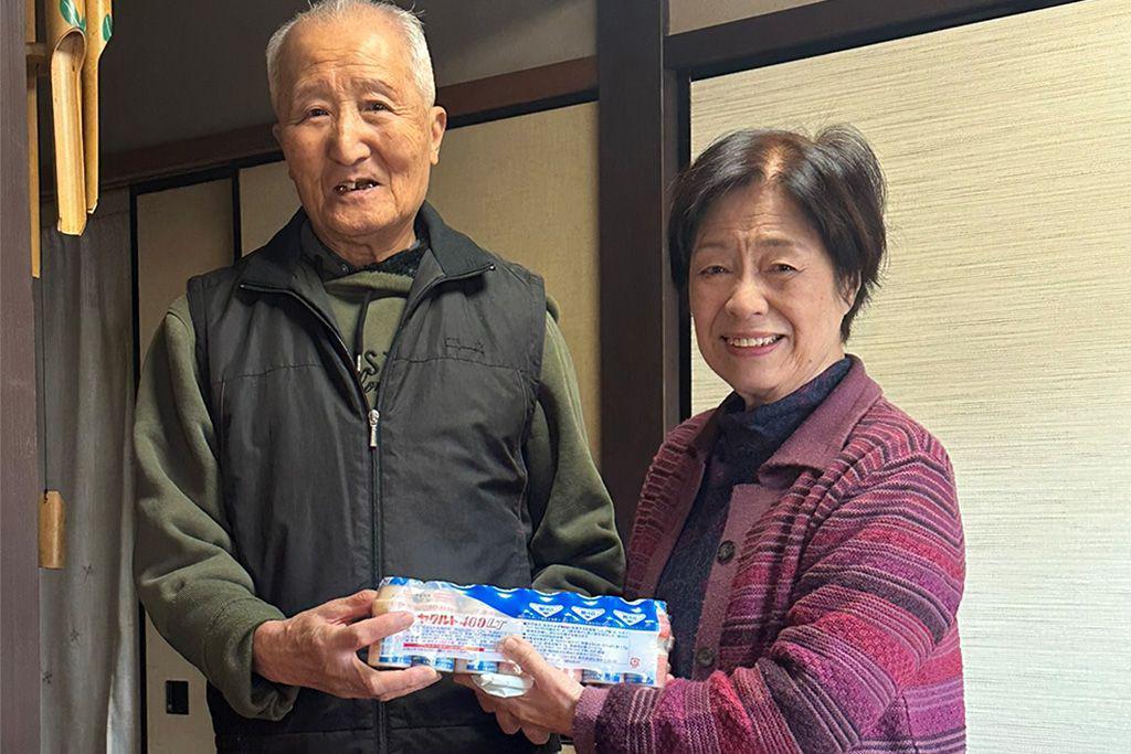 Dos personas mayores con yogures Yakult en la mano 
