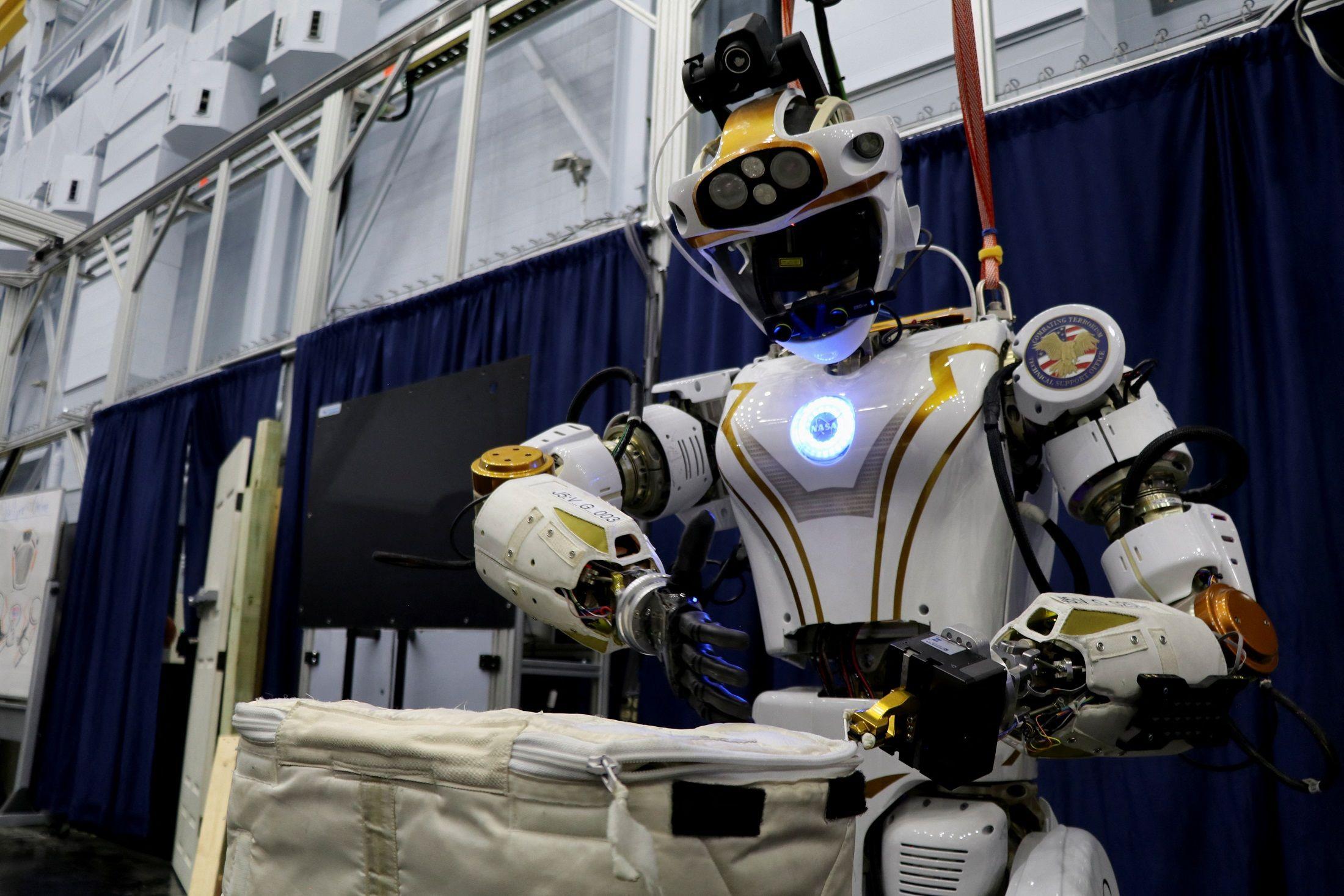 O robô humanoide Valkyrie da Nasa abrindo uma bolsa