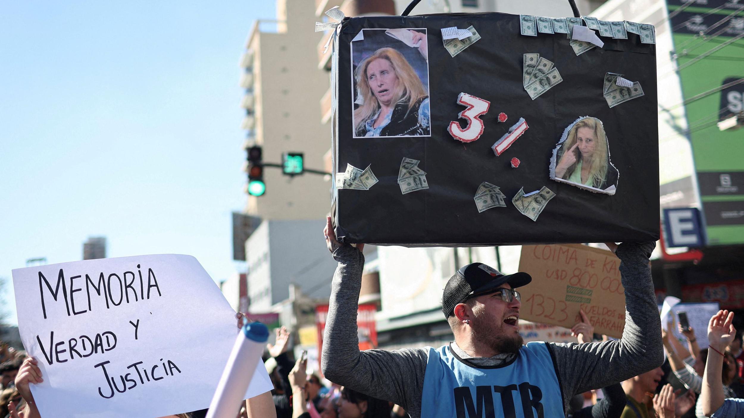 Un hombre sostiene un cartel en el que hace referencia al supuesto 3% que recibiría karina milei por los pagos de Andis a Suizo Argentina.