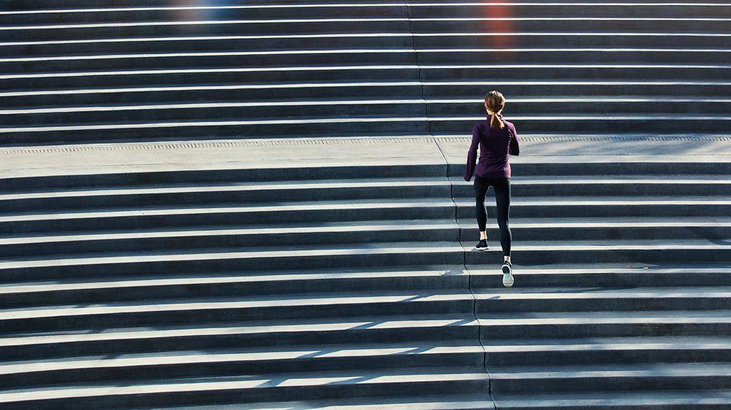 Pessoa de costas subindo uma escadaria