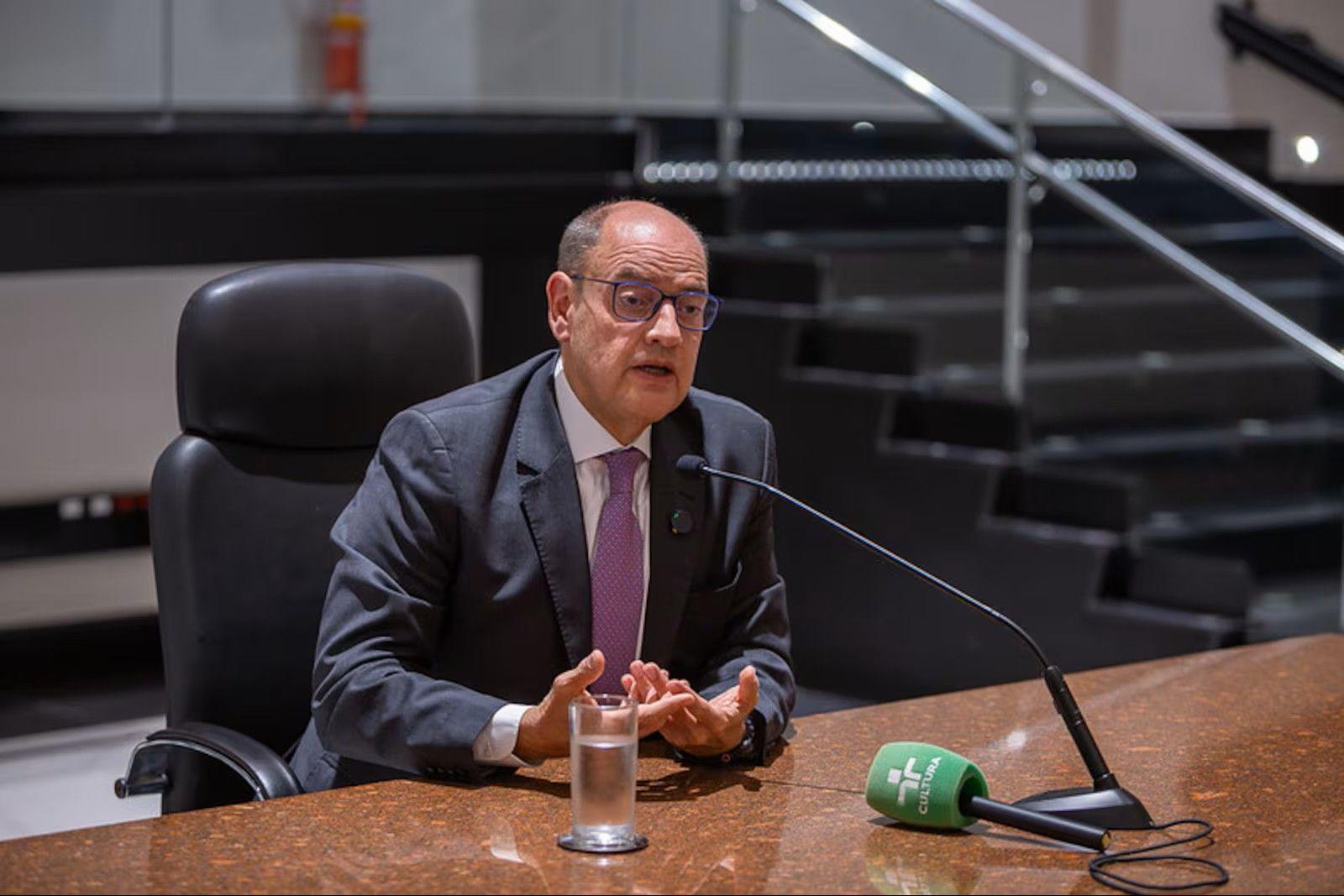 Desembargador sentado e falando em um microfone