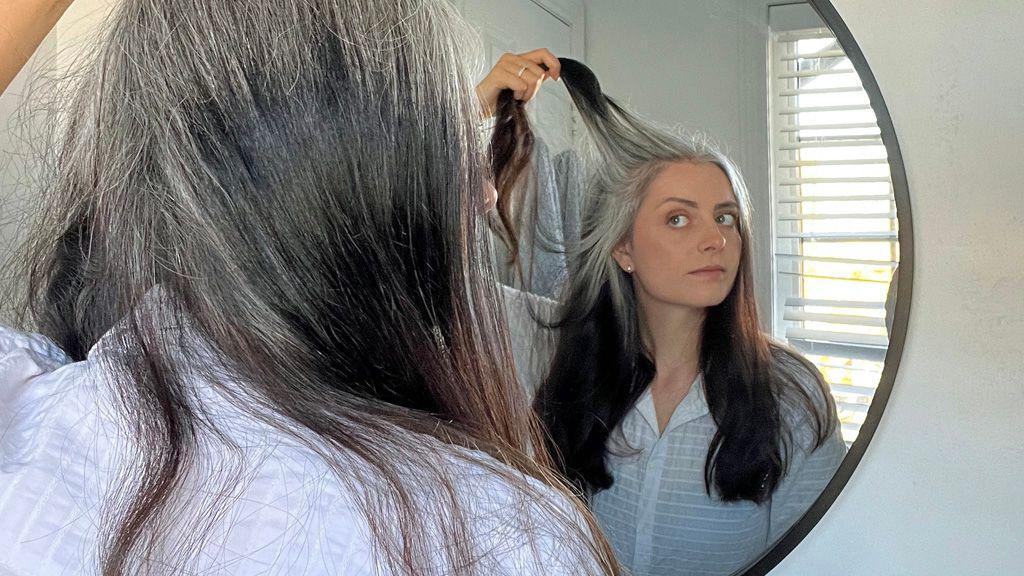 Foto de Ashley mirándose al espejo, con un mechón de pelo al aire.