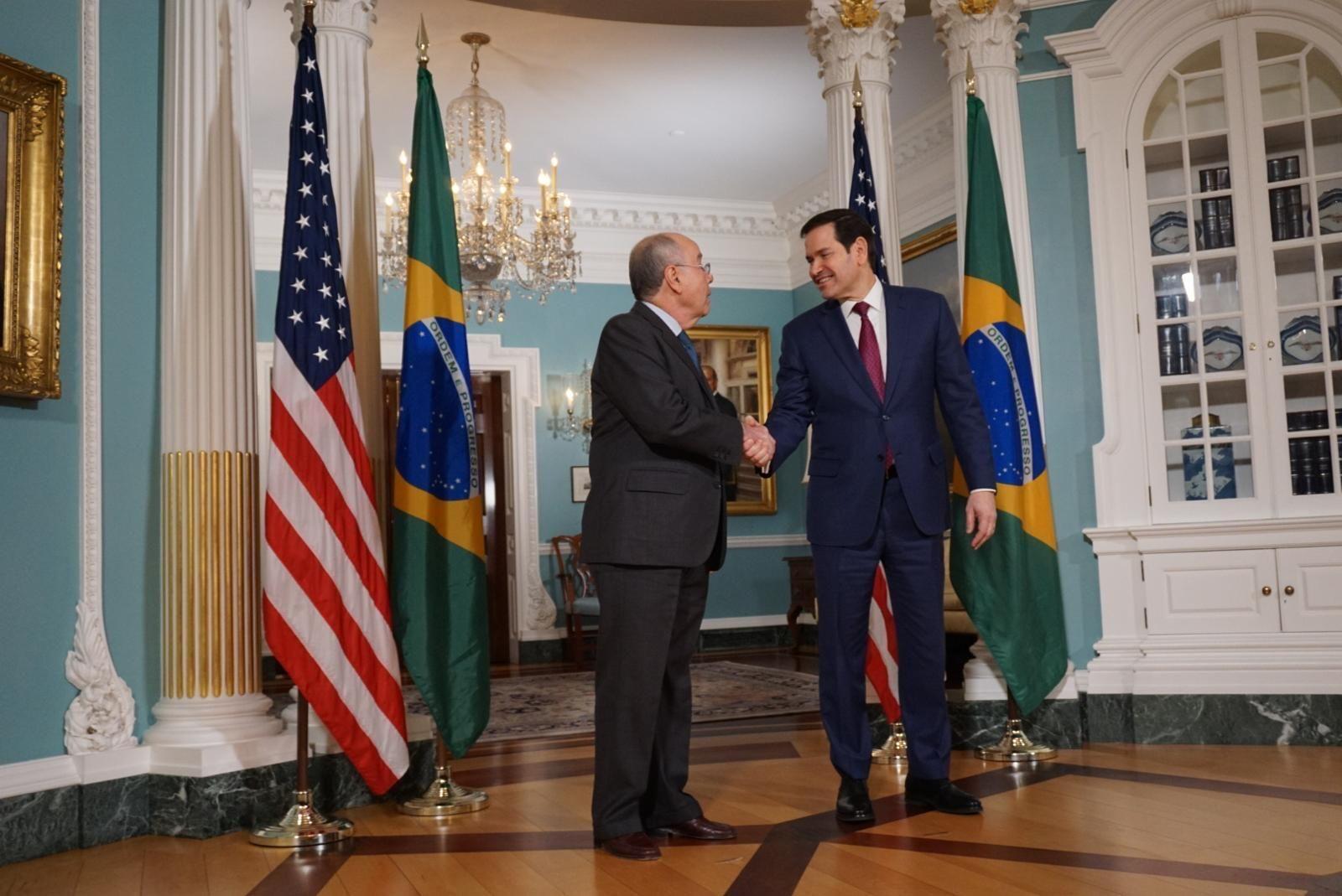 Vieira e Rubio apertando as mãos; Rubio sorri e Vieira olha atentamente para secretário americano; eles estão em salão requintado