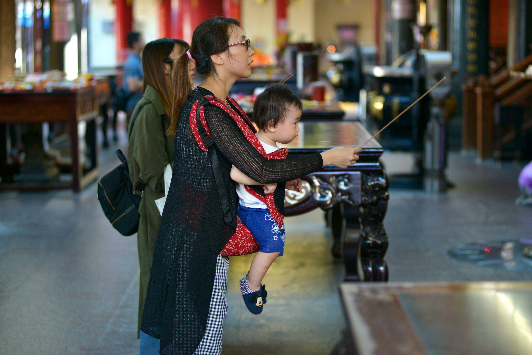 圖為一對母子在台灣宮廟參拜。