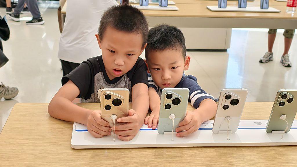 A child experiences playing puzzle games on a new smartphone at Huawei's world's largest flagship store in Shanghai, China on August 28, 2025