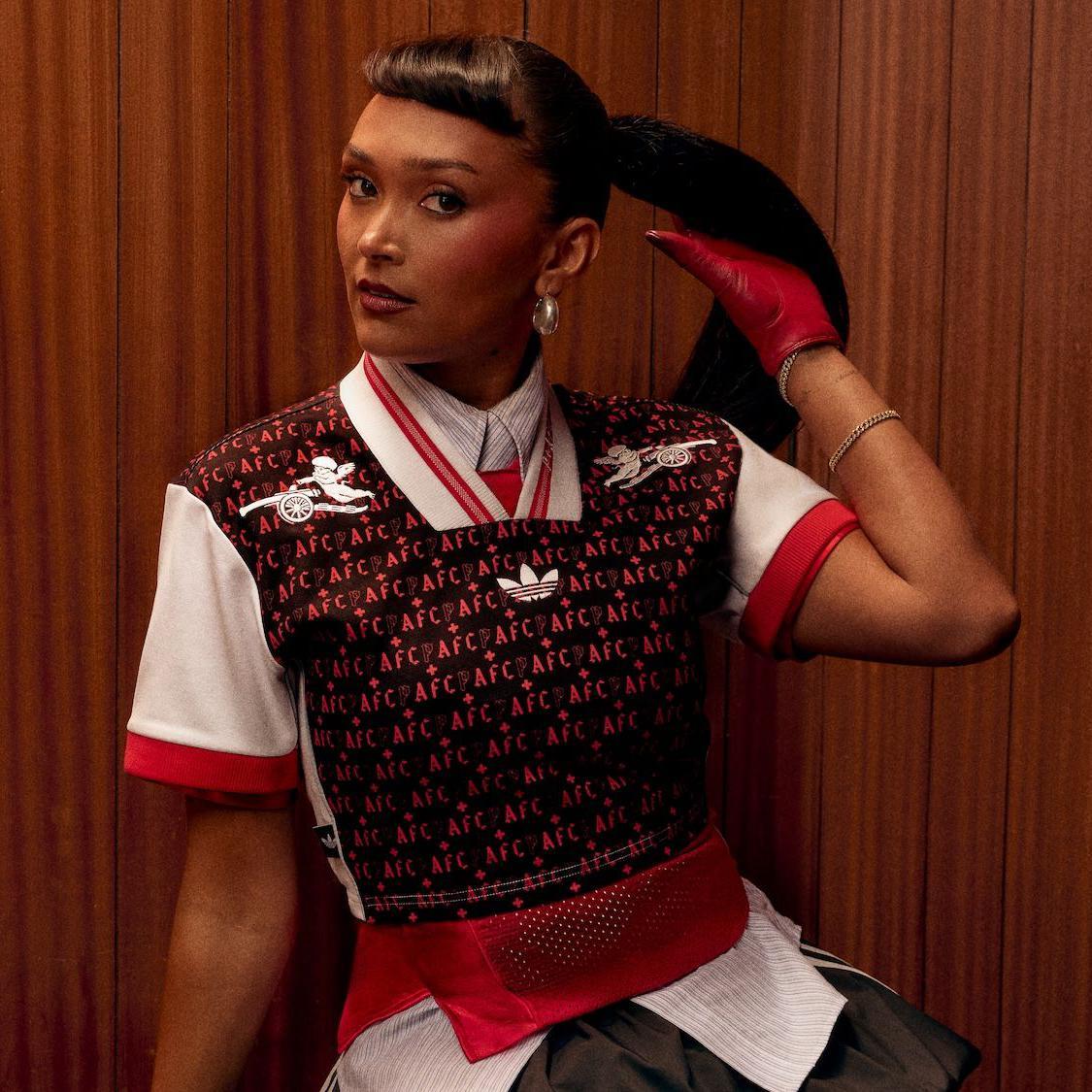 歌手 Joy Crookes 在木紋佈景板前身穿一件阿森納品牌上衣

