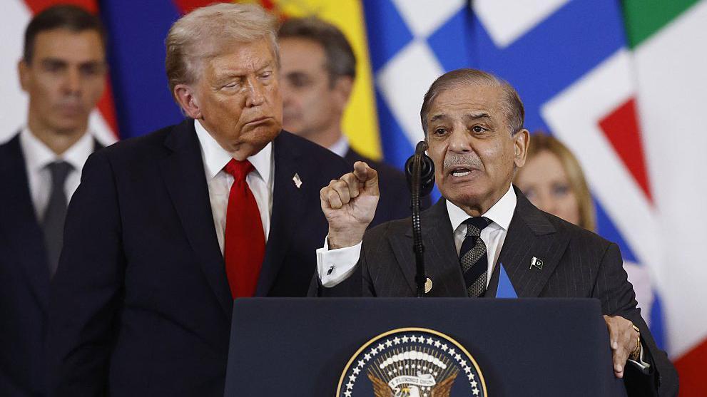 پاکستانی وزیر اعظم شہباز شریف پوڈیم پر بات کر رہے ہیں، پیچھے کھڑے امریکی صدر ڈونلڈ ٹرمپ ان کی بات سن رہے ہیں