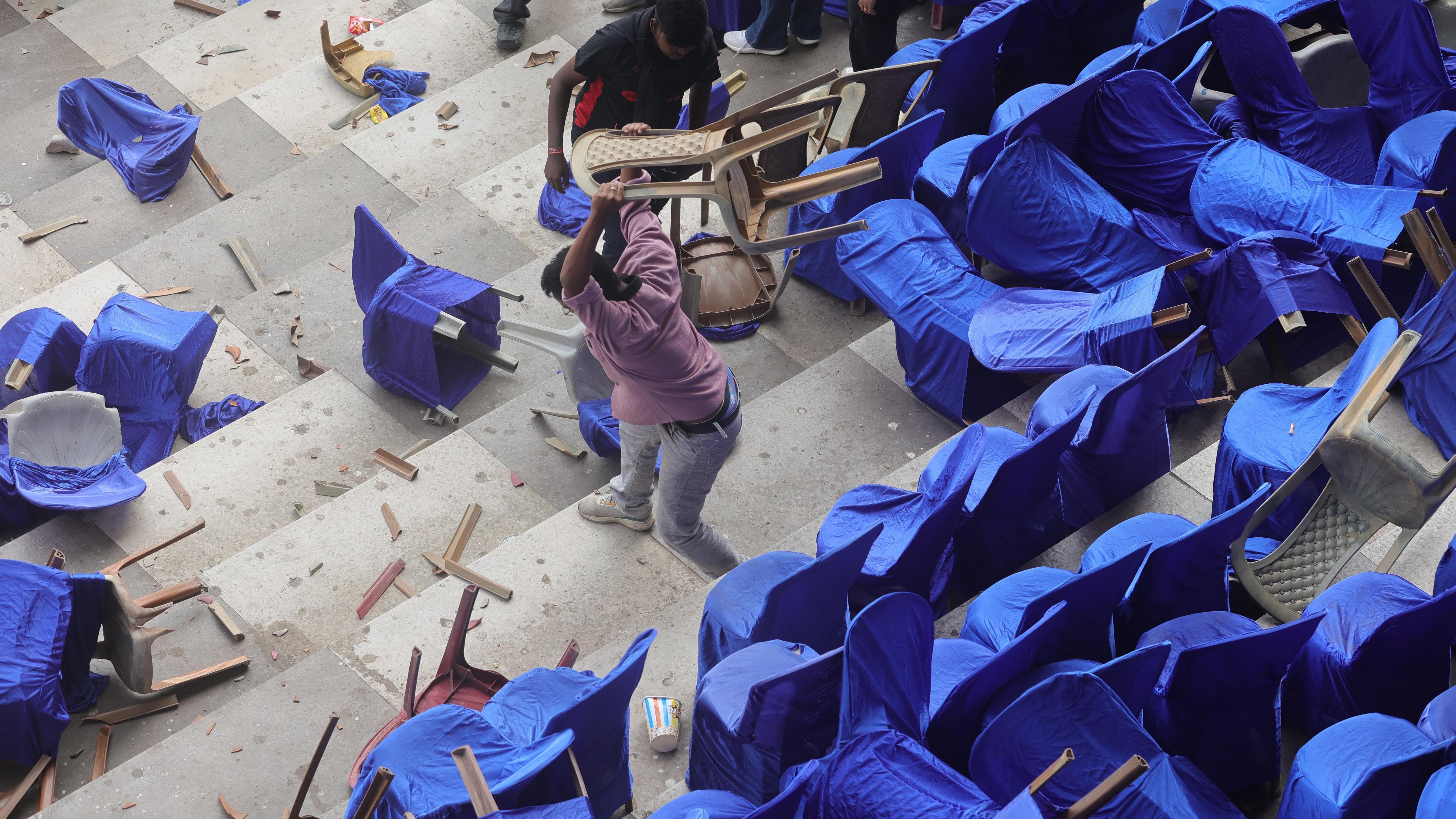 印度加爾各答鹽湖體育場內，一名男子在水泥看台上摔毀塑膠座椅（13/12/2025）