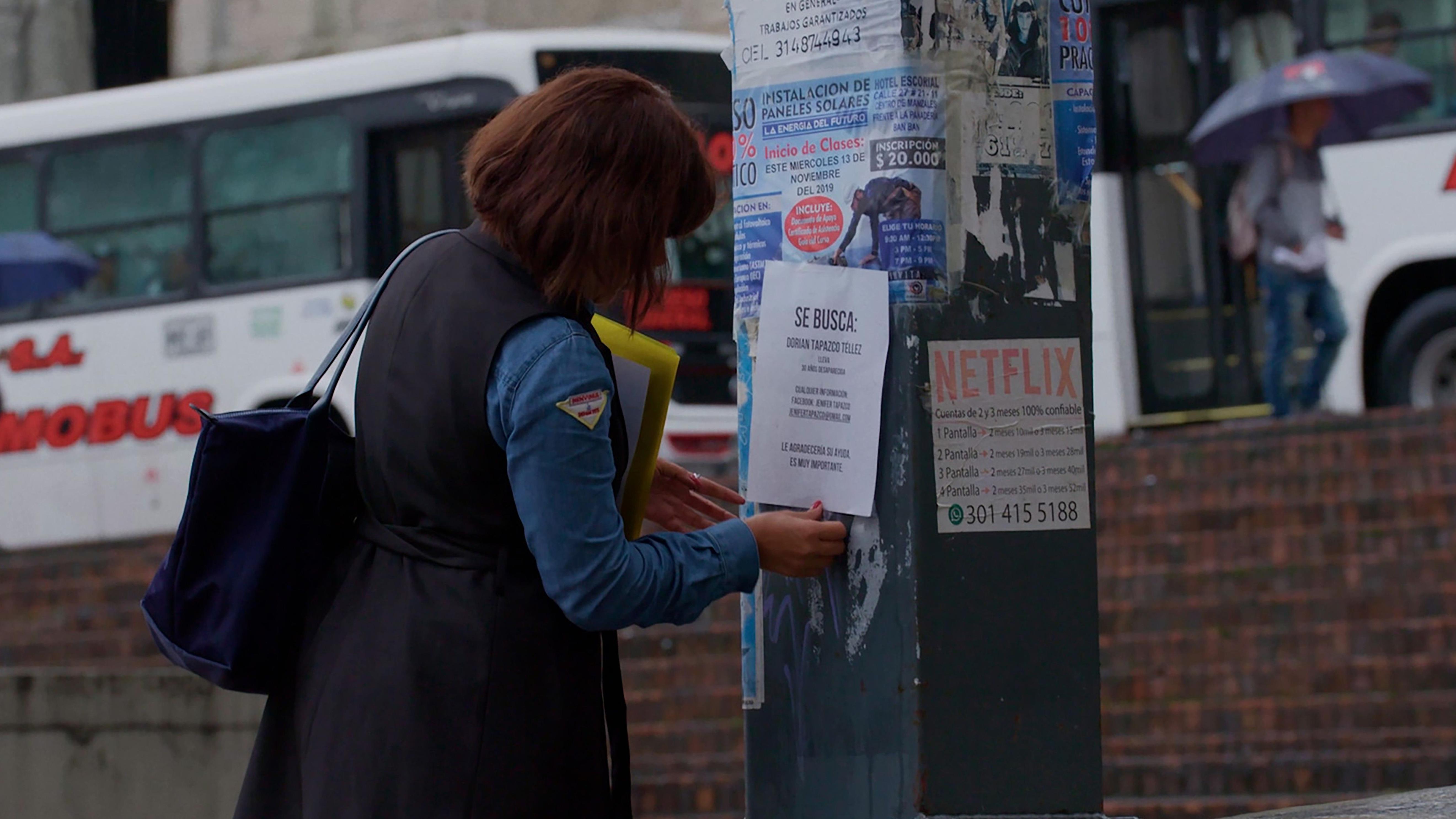 Imágenes del documental "Hija del volcán", donde se ve a Jenifer colgando afiches para dar con su madre.